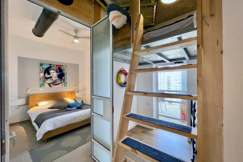 纳哈里亚Yamba יםבה באכזיב- פנטהאוז חדש ומפנק的一间卧室配有双层床和双层床梯子
