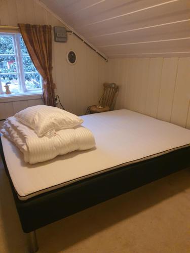 Övre KvammeTufte kårhus的一张位于小客房内的床铺,配有白色床单