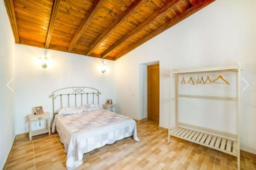 GenovésLa casa del bisa的一间卧室设有一张床和木制天花板