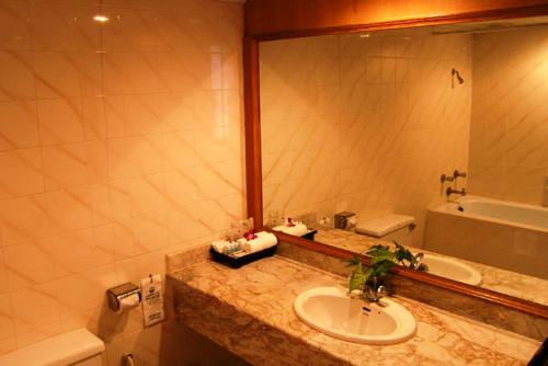 卡伦海滩Phuket Golden Sand Inn - SHA Extra Plus的浴室配有盥洗盆、镜子和浴缸