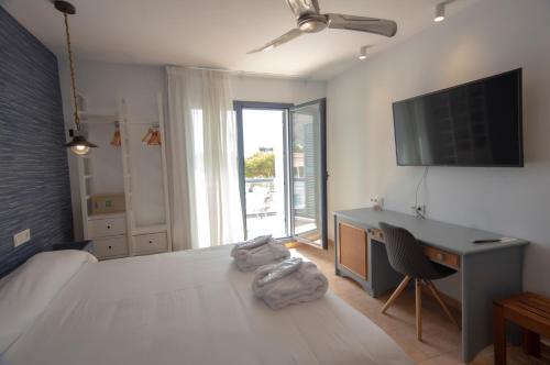 圣何塞Hotel La Posada De Paco - Spa & Adults Friendly的一间卧室配有一张床、一张书桌和一台电视