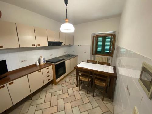 拉泰里纳Lo Sdrucciolo的厨房配有白色橱柜和桌椅