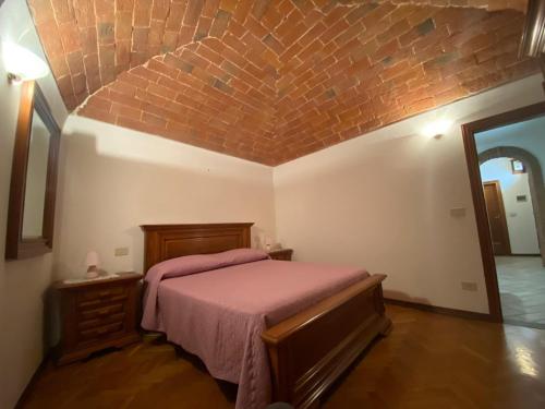 拉泰里纳Lo Sdrucciolo的一间卧室设有一张床和砖墙