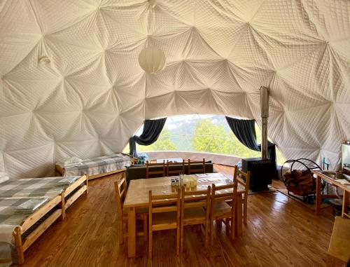 加格拉Эко-отель АтмоСФЕРА的用餐室配有带桌椅的帐篷