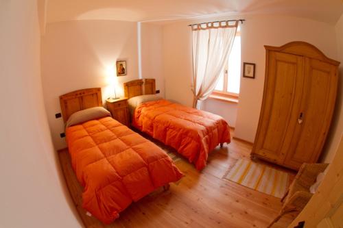 卡斯泰洛泰西诺Tesino Appartamenti 2的一间卧室设有两张床和窗户。