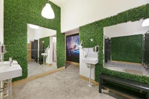 黄金海岸Tequila Sunrise Hostel Surfers Paradise的浴室设有两个水槽和绿色的墙壁。