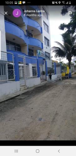 阿塔卡梅斯Casa blanca Atacames的棕榈树旁边的蓝色和白色的建筑