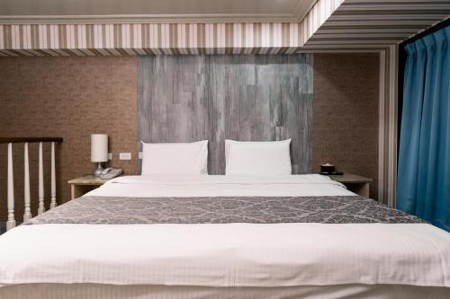 礁溪58度温泉汤苑会馆的卧室配有一张带蓝色窗帘的大型白色床