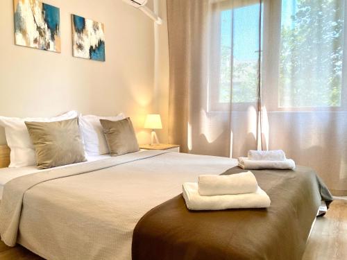旧扎戈拉City Centre Bright & Cozy Apartment for 4 persons的一间卧室配有一张大床和两条毛巾