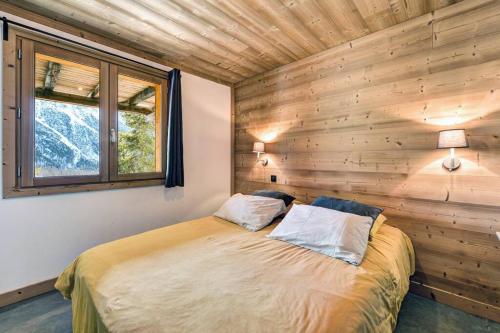 蒙热内夫尔Cosy Mountain _ free park的卧室配有木墙内的一张床