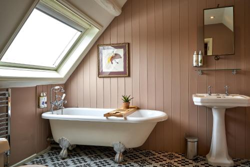 Charlton马和马夫酒店的浴室配有白色浴缸和水槽