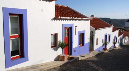 奥德赛克斯卡萨斯都莫音胡 - 赛车德阿尔德亚酒店的一排房子,有红色和蓝色的门