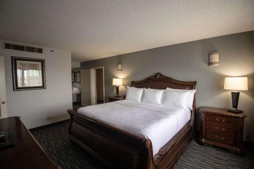 休斯顿Wyndham Houston near NRG Park - Medical Center的卧室配有一张带白色床单和枕头的大床。