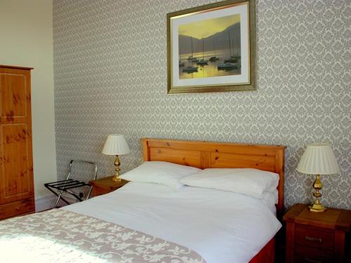 巴罗弗内斯欧姆斯吉尔宾馆的一间卧室配有一张带两盏灯的床,墙上挂着一张照片