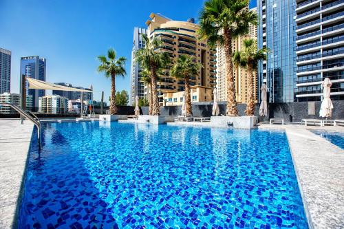迪拜Sparkle Tower, Dubai Marina的一座棕榈树和建筑的大型游泳池
