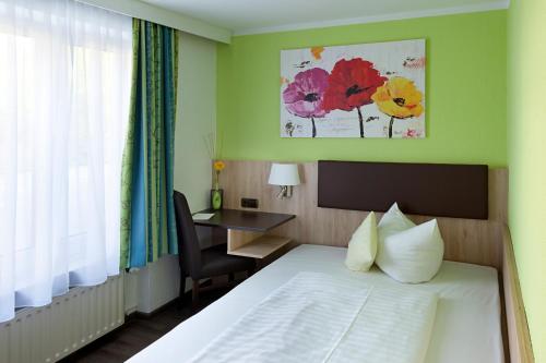 上施莱斯海姆蓝鲤鱼酒店的配有一张床、一张书桌和一扇窗户的酒店客房