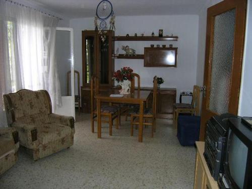 塞维利亚Piso en Sevilla Este的客厅配有桌椅和电视。