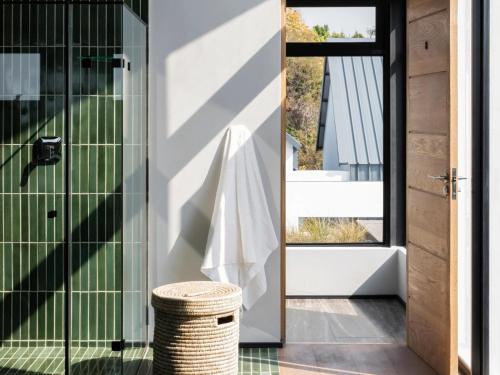 比勒陀利亚Askara Haus的浴室设有玻璃淋浴间和柳条凳