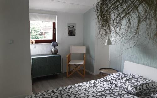 巴特萨克萨Chalet的卧室配有床、椅子和窗户。