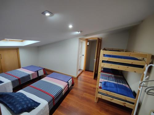 坎加斯德穆拉索Rapadouro的铺有木地板的客房内配有两张双层床。