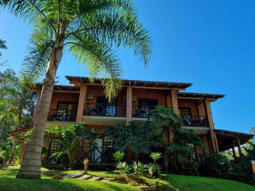 加斯帕Pousada Arraial do Ouro的前面有棕榈树的房子