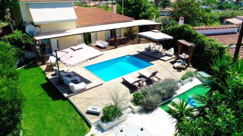 圣帕拉斯凯维Serenity Luxury Villa, Skiathos的享有带游泳池的房屋的空中景致