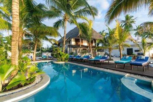 江比阿Casa Paradis的一个带蓝椅和棕榈树的度假村游泳池