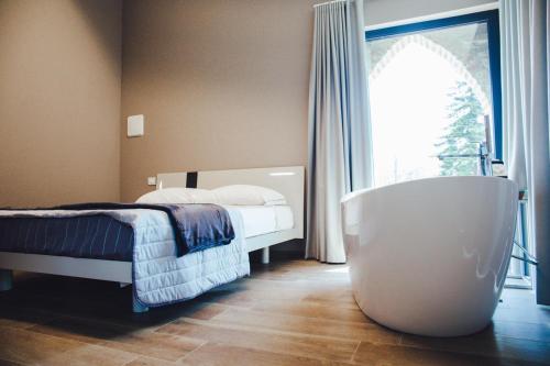 Castelvetro PiacentinoL’infinito residence的一间带浴缸、床和窗户的卧室