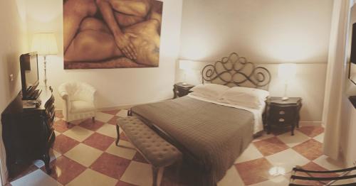 摩德纳La Corte Dei Sogni B&B的卧室配有一张床,墙上挂有绘画作品