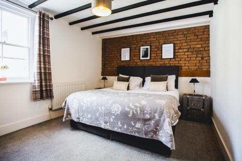 切普斯托No8 Chepstow的一间卧室设有一张大床和砖墙