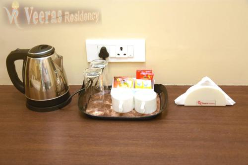 蓬蒂切里Veeras Residency的桌上的带蜡烛和茶壶的托盘