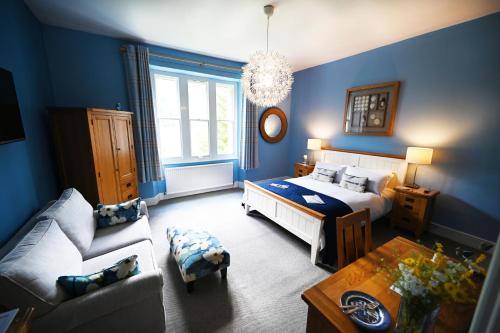 马汉莱斯The Old Vicarage B&B, Corris的蓝色的客房配有床和沙发
