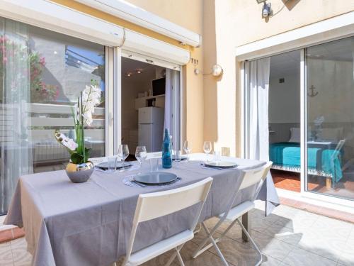 乐巴凯尔斯Apartment Les Cabestans 1-2-3-4 by Interhome的餐桌、蓝桌布和白色椅子
