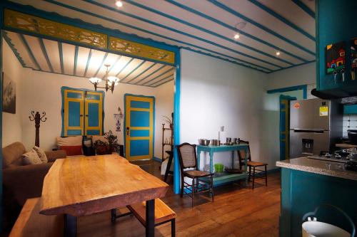 萨兰托Real House Salento的一间带桌子的客厅和一间带蓝色门的厨房