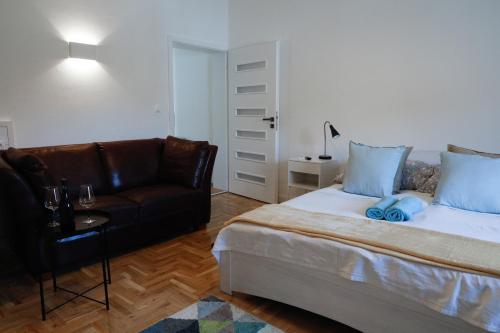科马罗姆Apartman 3的一间卧室配有一张床和一张皮沙发