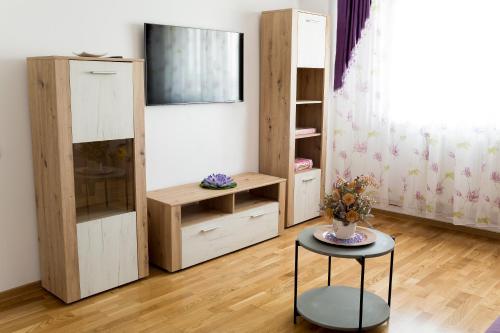 图尔恰Diana Sunshine Apartment的一间设有木架和一张带花瓶的桌子的房间