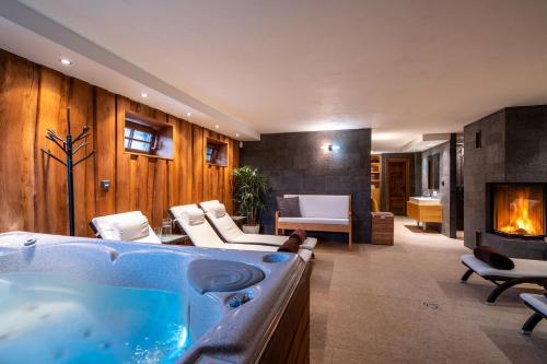 斯祖贝莱克Chalet Zuberec, 5 apartments, jacuzzi, sauna, mountains的一间带浴缸和壁炉的客厅