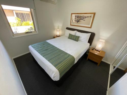 埃默拉尔德翡翠酒店的一间卧室设有一张大床和一个窗户。