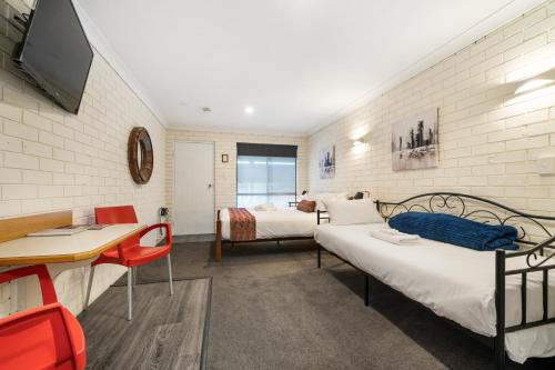 Esk埃斯克威文霍汽车旅馆的客房设有两张床、一张桌子和一台电视机。