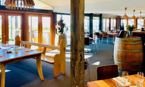 奥兰治博罗戴尔葡萄园度假酒店的一间设有木桌和木桶的餐厅