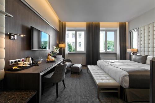 维尔纽斯Congress Avenue Hotel的酒店客房配有一张床、一张书桌和一张书桌。