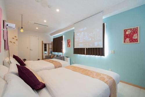东京Kiba no Tsuru Carane Hotel - Vacation STAY 40658v的酒店客房设有两张床和大屏幕