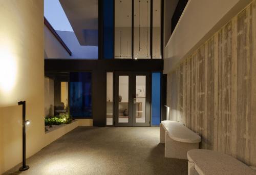 利马索尔Alinea Suites Limassol Center的带窗户和椅子的走廊客房