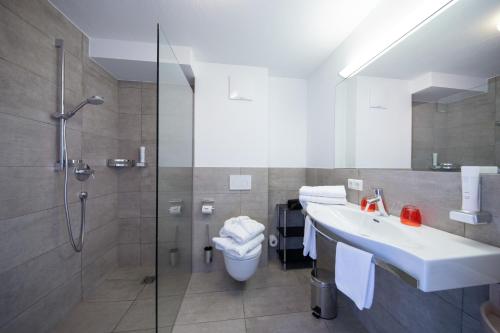 滨湖采尔Schmiedhof Alm的带淋浴、盥洗盆和卫生间的浴室