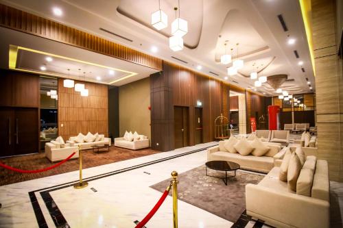 名古屋Asialink Hotel Batam by Prasanthi的大堂设有白色的沙发和红色的绳索