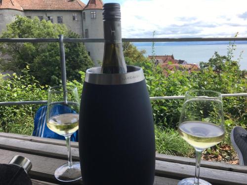梅尔斯堡Ferienwohnungen Bohner/ Wohnung Katharina的一张桌子上放着一瓶葡萄酒,放上两杯