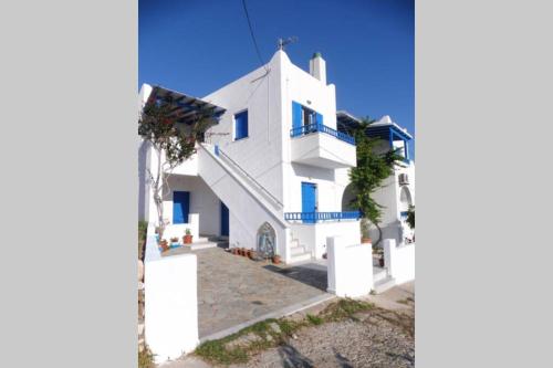 阿波罗3 min from the beach-White&blue house in Apollon的白色的房子,设有蓝色的窗户和楼梯