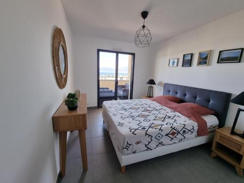 Grosseto-PrugnaLoCorse - Superbe appartement T2 avec une belle vue mer的一间卧室配有一张床、一张桌子和一个窗户。