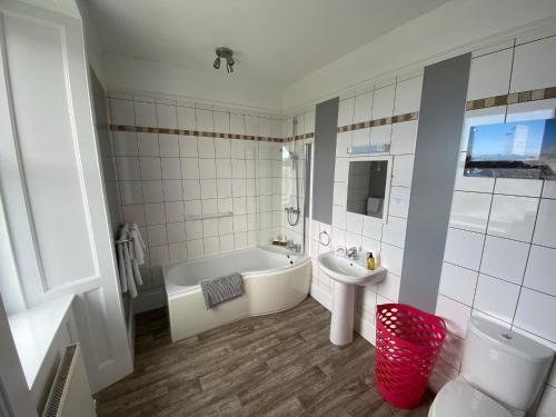BowmoreThe Bowmore House Bed and Breakfast的白色的浴室设有浴缸和水槽。
