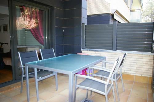 滨海托萨Apartamento PR 39 terraza y piscina Tossa de Mar的天井上的蓝色桌椅